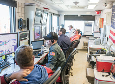 Committed control room personnel monitor pipeline flow
